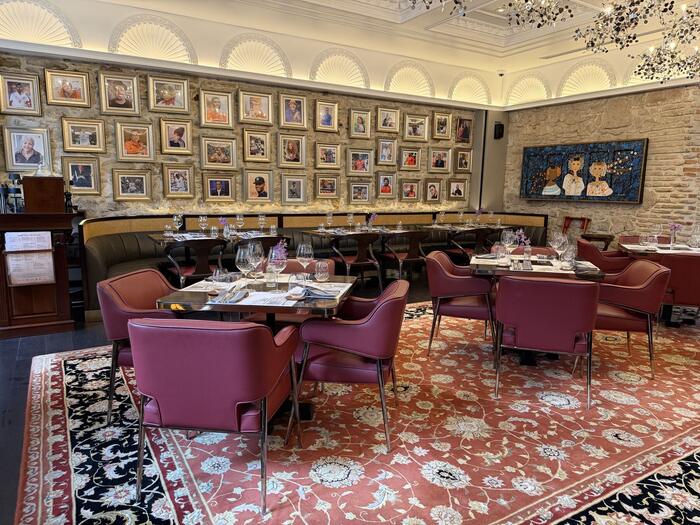 Dining room seating beneath a wall of framed portraits