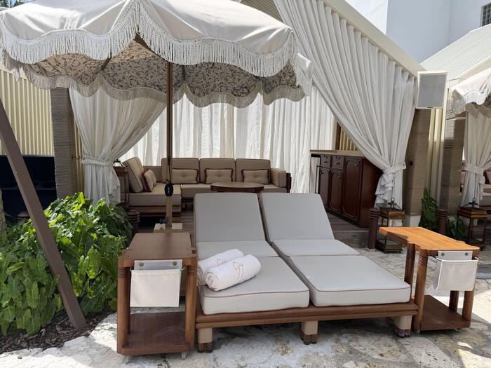 Poolside cabana with draped curtains and lounge seating